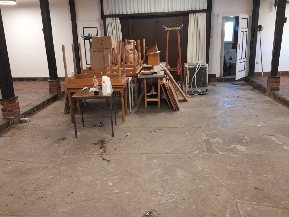 Halle mit aufgestapelten alten Möbeln vor der Entrümpelung